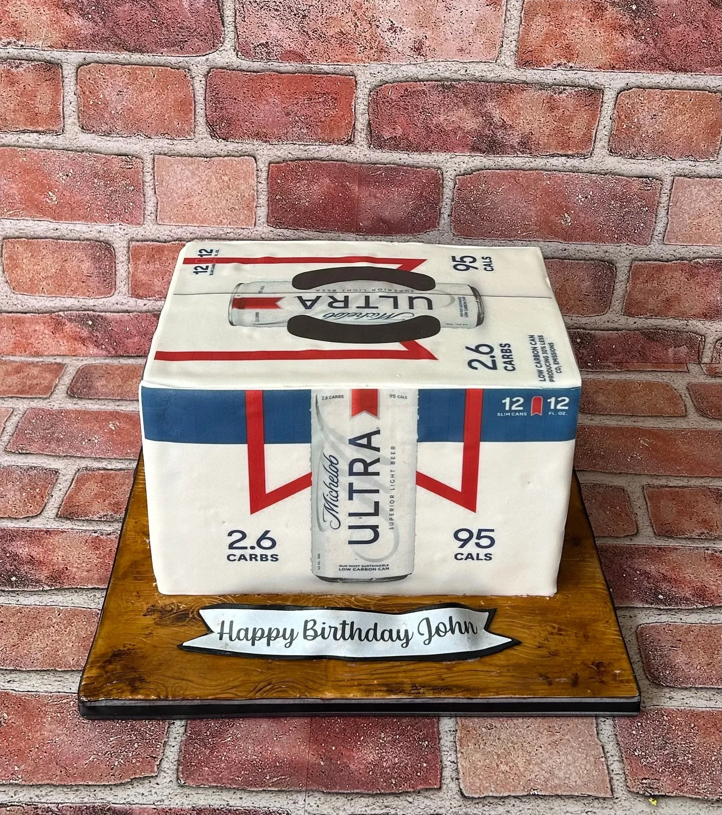 Sculpted cake shaped as a printed beer case with a Happy Birthday banner