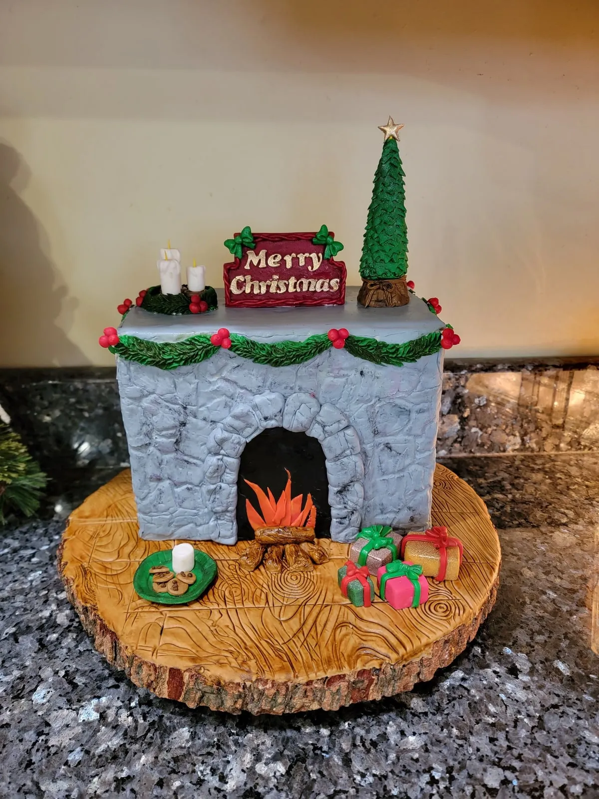 Sculpted Christmas fireplace cake with stone detail, stockings and a lit hearth