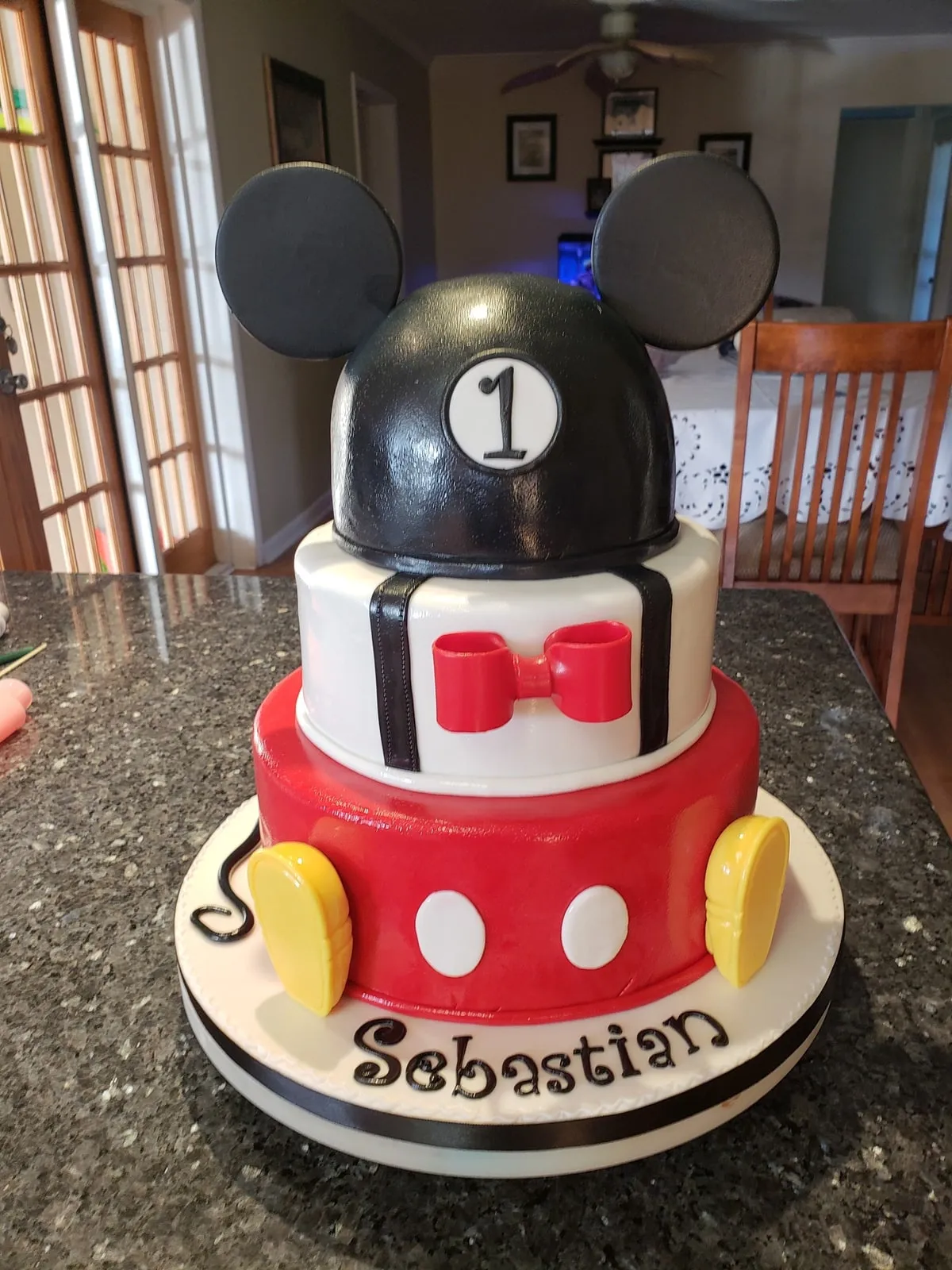 Mickey Mouse first birthday cake with sculpted ears, red shorts and bow tie
