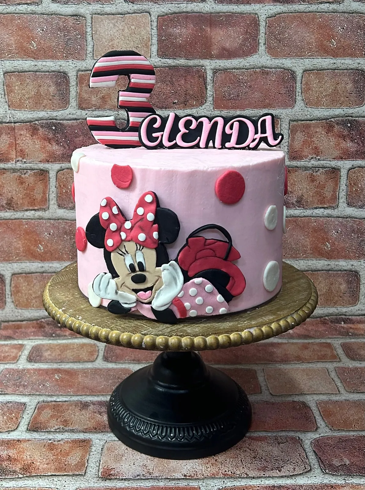 Minnie Mouse birthday cake in red and pink polka dots with a hand cut figure