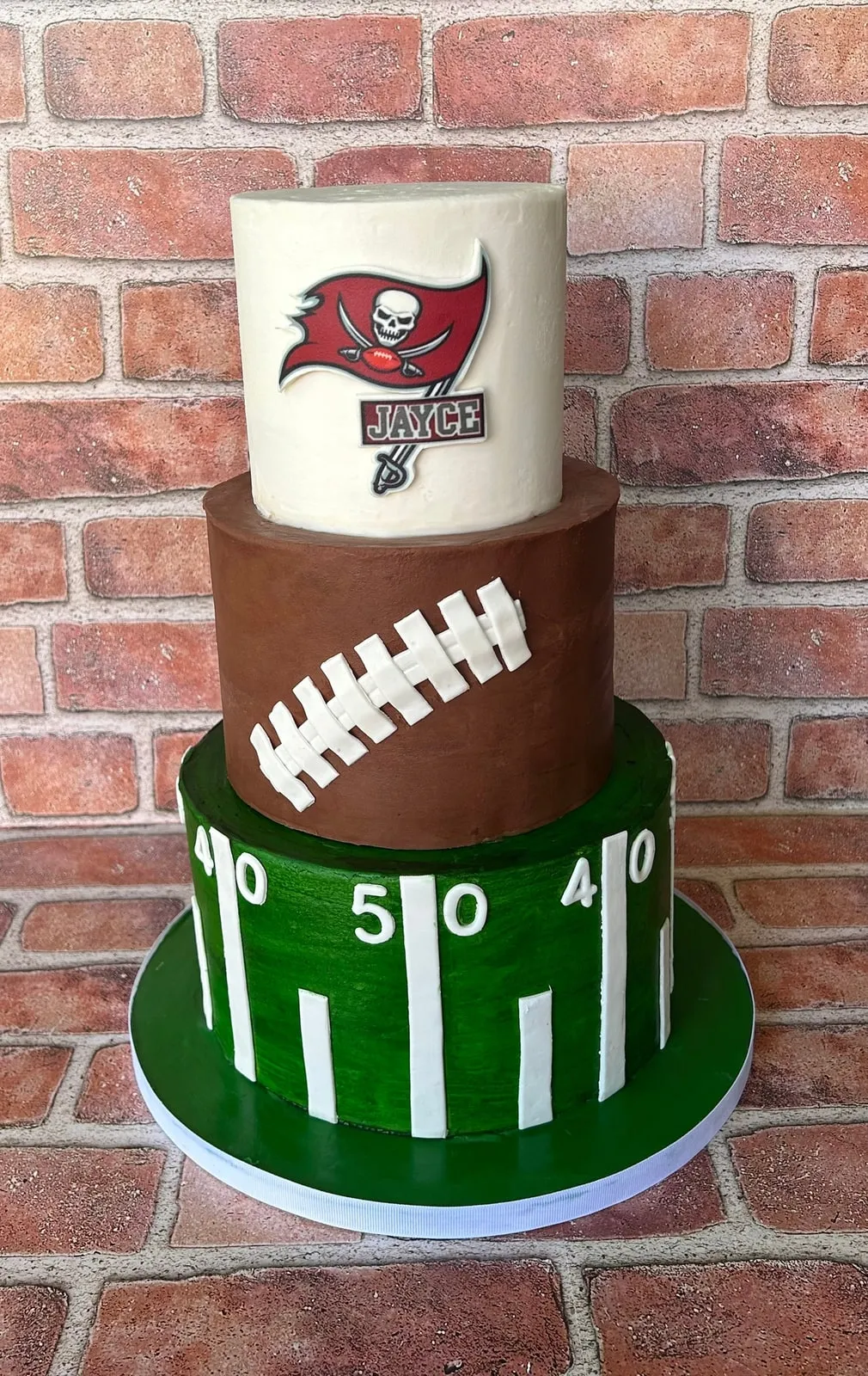 Tampa Bay Buccaneers football cake with a sculpted ball tier and green field base