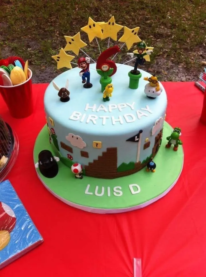 Video game themed birthday cake with hand modelled characters on a green board
