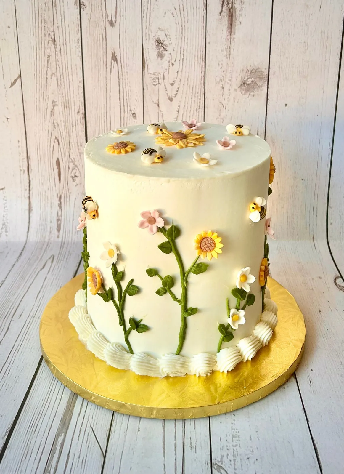 Ivory buttercream cake hand piped with daisies and wildflowers