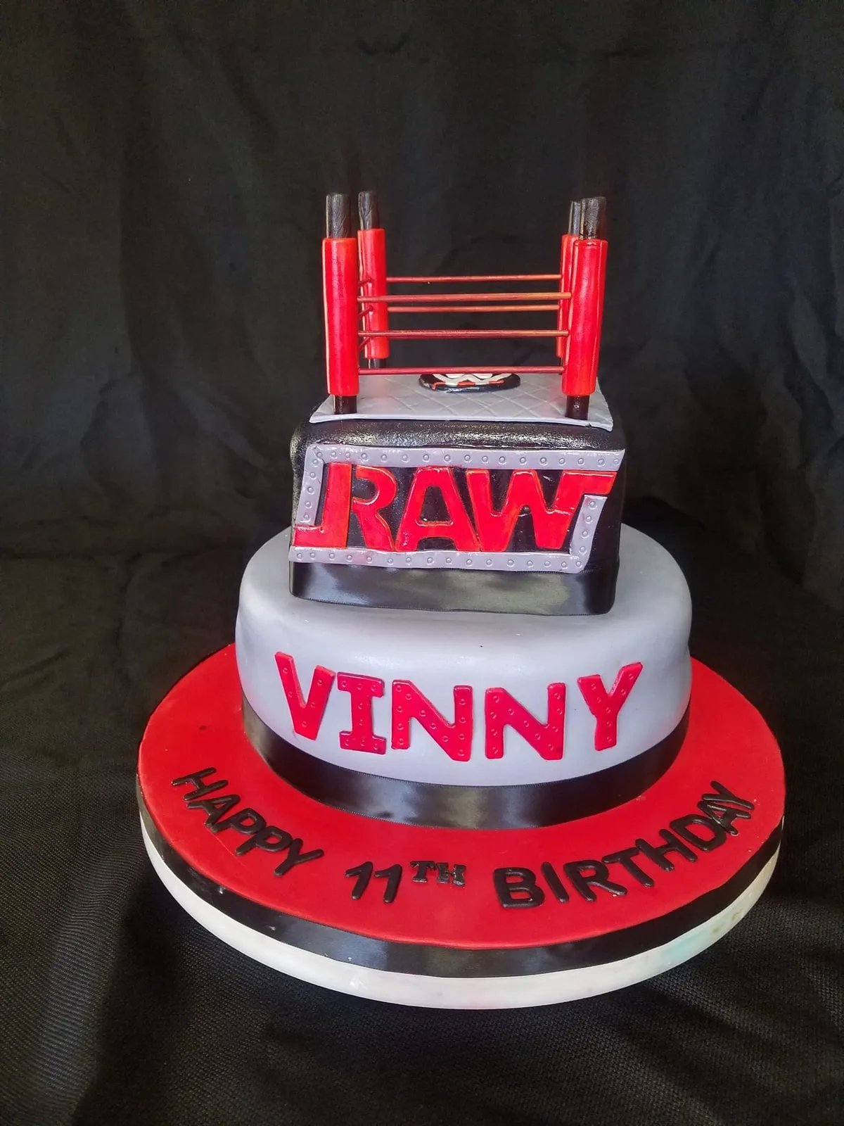 Wrestling ring birthday cake with sculpted ropes, turnbuckles and red banner